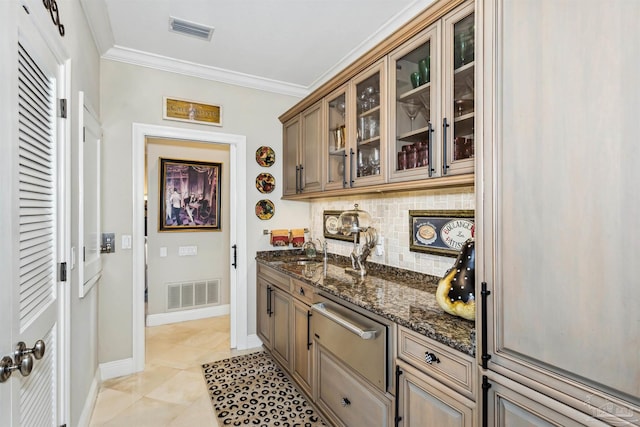 kitchen featuring dark stone counters, sink, light tile patterned floors, crown molding, and decorative backsplash