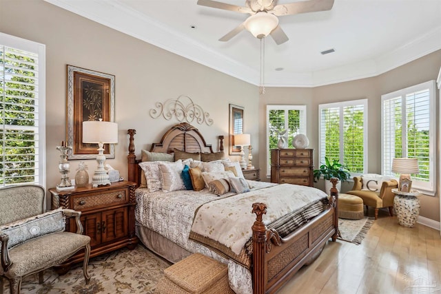 bedroom featuring light hardwood / wood-style floors, ceiling fan, and crown molding