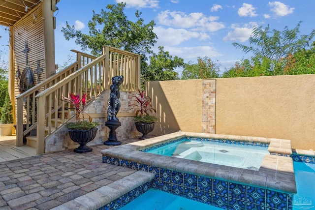 view of swimming pool featuring an in ground hot tub, a patio, and a deck