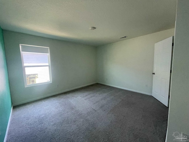 carpeted spare room featuring a textured ceiling