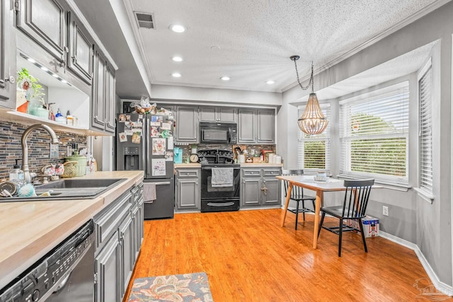 2803 Venetian Way, Gulf Breeze, FL 32563 - kitchen with black appliances, gray cabinets, a sink, backsplash, and crown molding