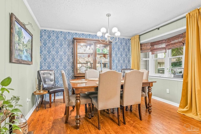 2803 Venetian Way, Gulf Breeze, FL 32563 - dining area featuring crown molding, a textured ceiling, a chandelier, wood finished floors, and baseboards