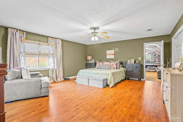 2803 Venetian Way, Gulf Breeze, FL 32563 - bedroom with multiple windows, a textured ceiling, light wood-style floors, and a ceiling fan