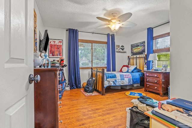 2803 Venetian Way, Gulf Breeze, FL 32563 - bedroom with multiple windows, a textured ceiling, wood finished floors, and ceiling fan