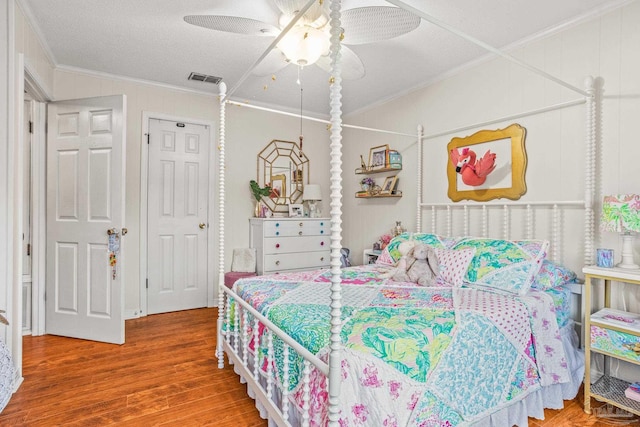 2803 Venetian Way, Gulf Breeze, FL 32563 - bedroom with crown molding, wood finished floors, a ceiling fan, and a textured ceiling
