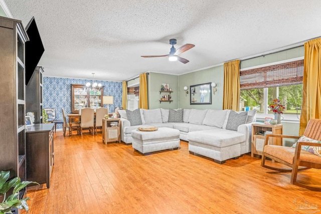 2803 Venetian Way, Gulf Breeze, FL 32563 - living area with wallpapered walls, a textured ceiling, a chandelier, light wood-style floors, and ceiling fan