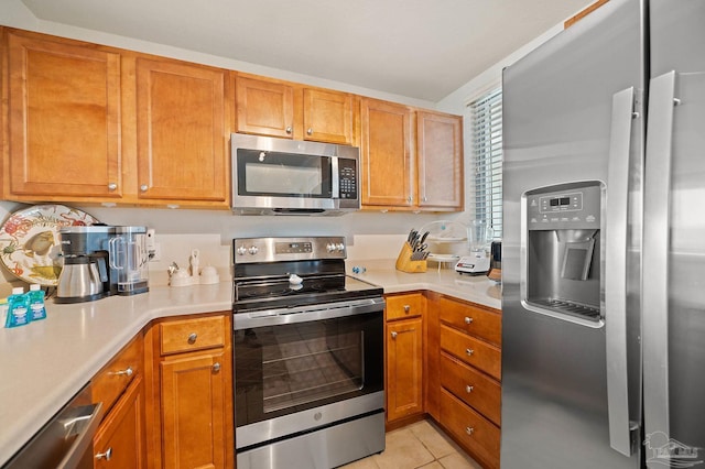850 Ft Pickens Rd Unit 540, Pensacola Beach, FL 32561 - kitchen featuring light countertops, light tile patterned flooring, stainless steel appliances, and brown cabinets