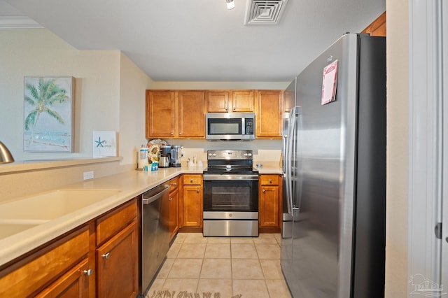 850 Ft Pickens Rd Unit 540, Pensacola Beach, FL 32561 - kitchen featuring light tile patterned flooring, visible vents, brown cabinets, appliances with stainless steel finishes, and a sink
