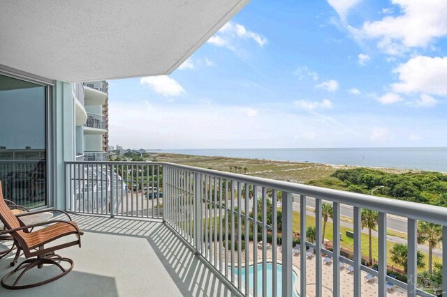 balcony featuring a fenced in pool and a water view