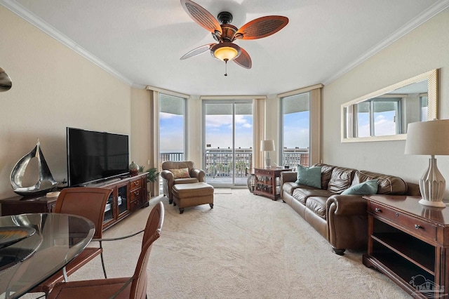 living room featuring ceiling fan, a healthy amount of sunlight, ornamental molding, and light colored carpet