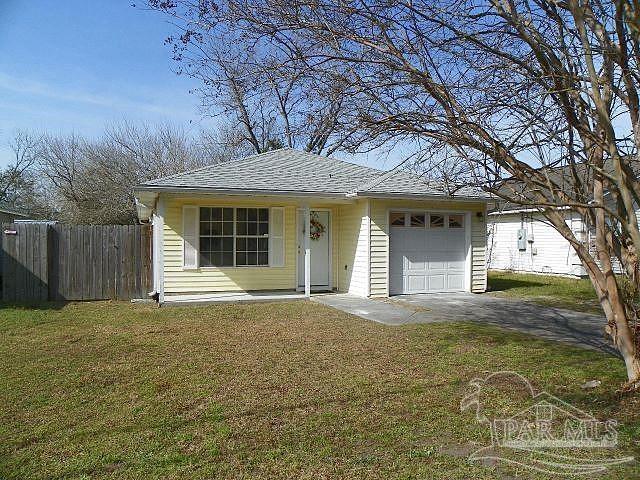 view of front of home with a garage and a front lawn