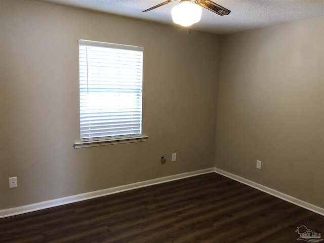 unfurnished room featuring ceiling fan, baseboards, dark wood finished floors, and a textured ceiling