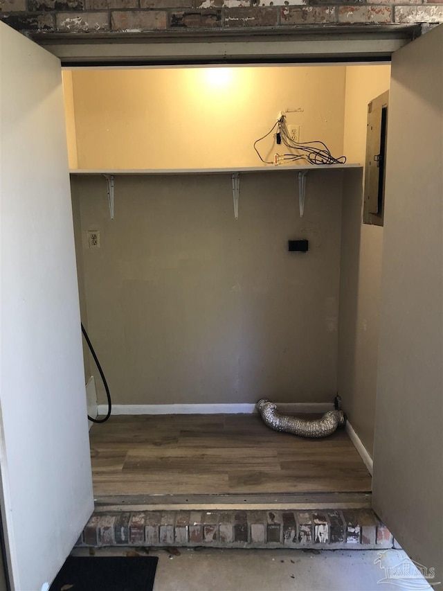 laundry room with electric panel, baseboards, hookup for an electric dryer, and wood finished floors