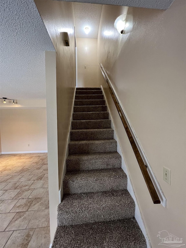 stairway with a textured ceiling