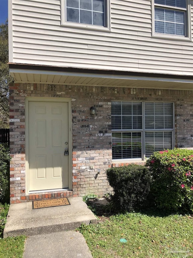 entrance to property featuring brick siding