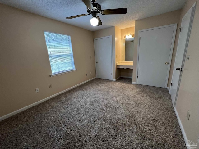 unfurnished bedroom featuring light carpet, connected bathroom, baseboards, and a textured ceiling