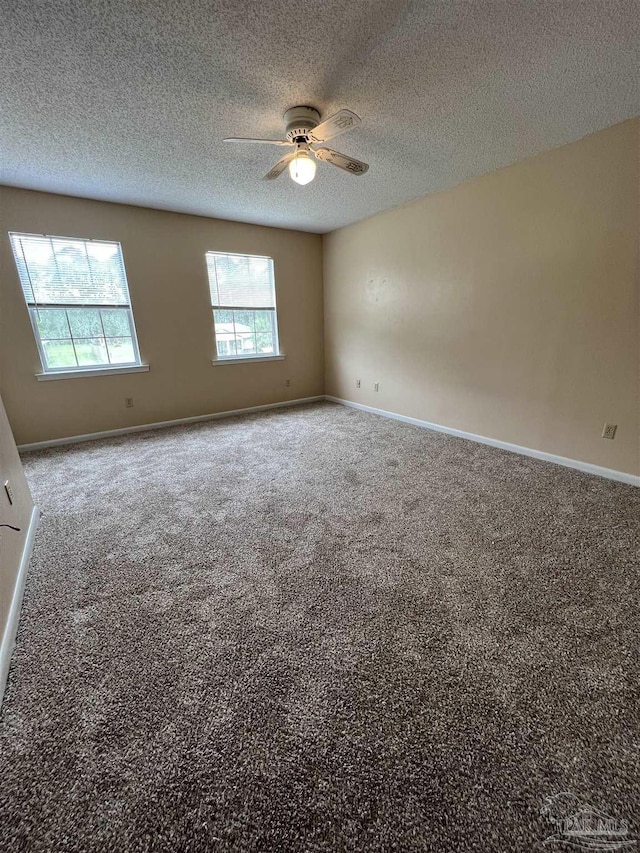 carpeted empty room with a ceiling fan, a textured ceiling, and baseboards