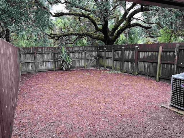 view of yard with a fenced backyard and central air condition unit