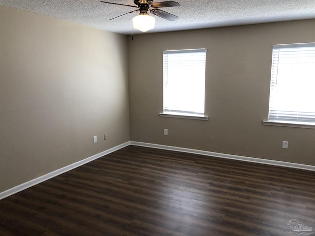 spare room featuring ceiling fan, a textured ceiling, baseboards, and dark wood-type flooring