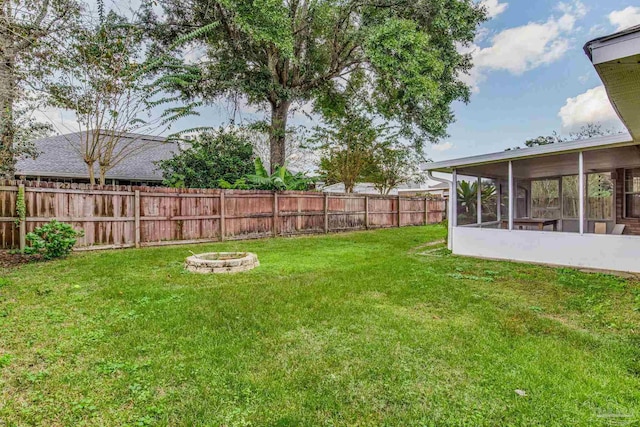 view of yard featuring a sunroom and a fire pit