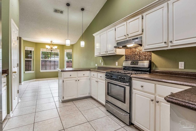 kitchen featuring kitchen peninsula, gas range, white cabinetry, and lofted ceiling