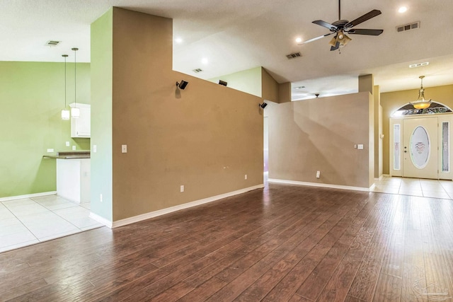 unfurnished living room featuring ceiling fan, a textured ceiling, high vaulted ceiling, and light hardwood / wood-style flooring