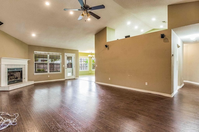 unfurnished living room featuring high vaulted ceiling, ceiling fan, a textured ceiling, a fireplace, and dark hardwood / wood-style flooring