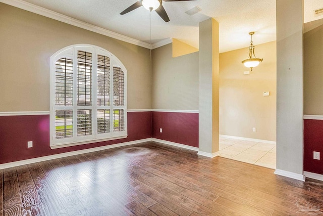 unfurnished room with hardwood / wood-style floors, ceiling fan, ornamental molding, and a textured ceiling