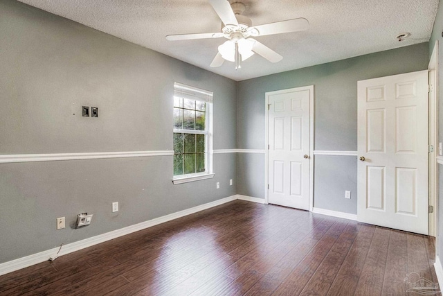 unfurnished bedroom featuring a textured ceiling, dark hardwood / wood-style flooring, and ceiling fan