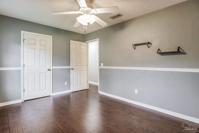 unfurnished bedroom with ceiling fan, dark wood-type flooring, and a textured ceiling