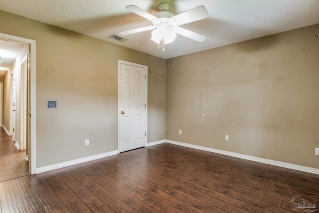 spare room featuring ceiling fan, dark hardwood / wood-style flooring, and a textured ceiling