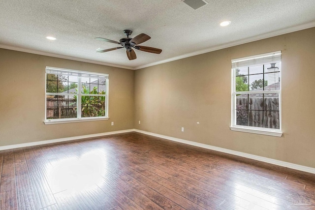 empty room featuring dark hardwood / wood-style flooring, a textured ceiling, and a healthy amount of sunlight