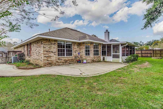 back of house featuring a yard, a patio area, and a sunroom