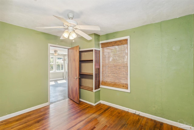 unfurnished bedroom with hardwood / wood-style flooring, a closet, and ceiling fan