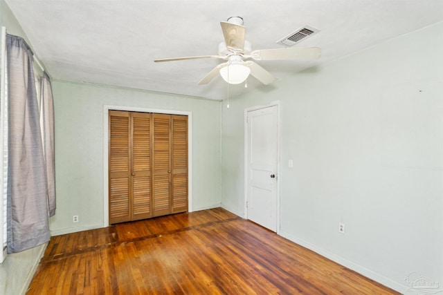 unfurnished bedroom with a closet, ceiling fan, and dark hardwood / wood-style flooring