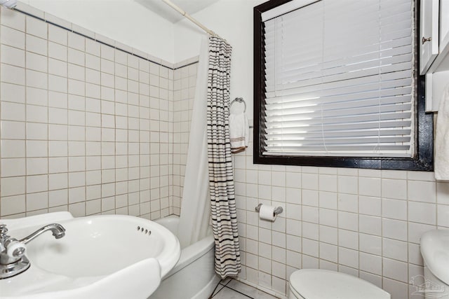 full bathroom with tile walls, sink, shower / bath combination with curtain, and toilet