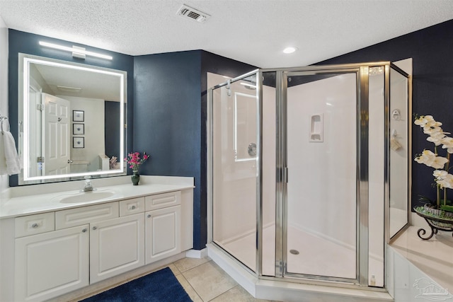 bathroom with tile patterned flooring, visible vents, a shower stall, and a textured ceiling