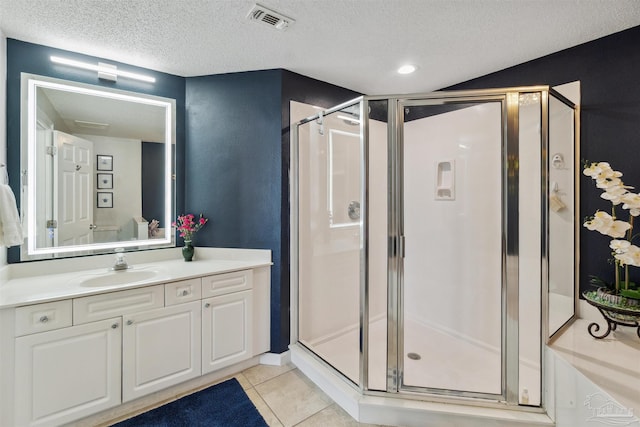 bathroom featuring visible vents, a shower stall, vanity, tile patterned floors, and a textured ceiling