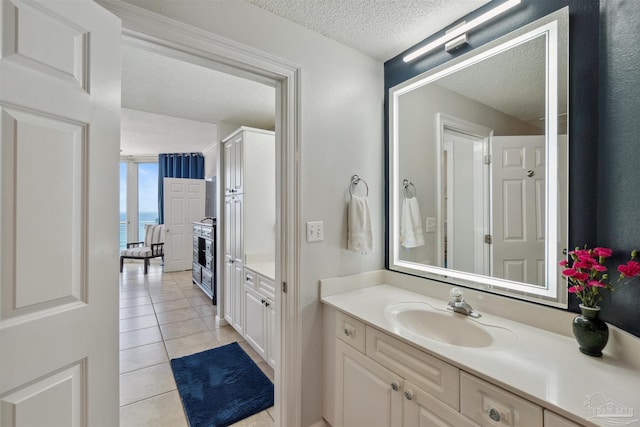 bathroom with tile patterned floors, a textured ceiling, and vanity