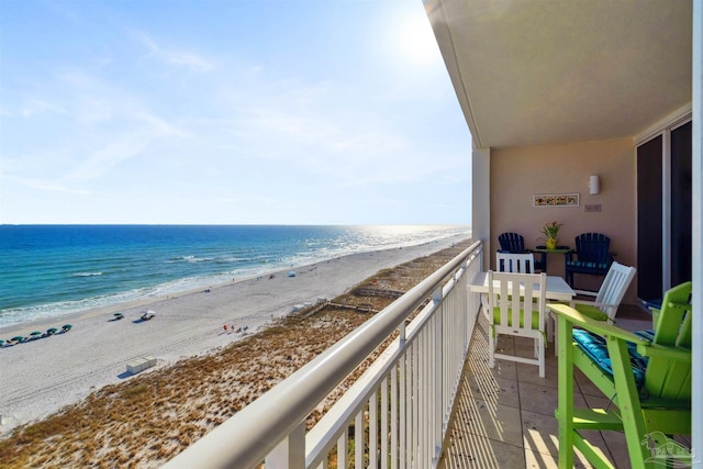 balcony featuring a view of the beach and a water view