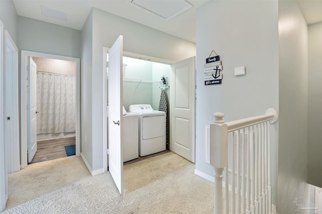 laundry area featuring washing machine and dryer and light carpet