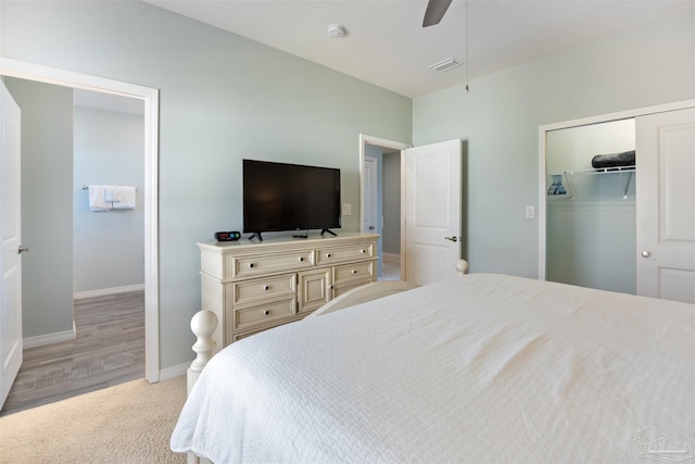 bedroom with a walk in closet, ceiling fan, a closet, and light wood-type flooring