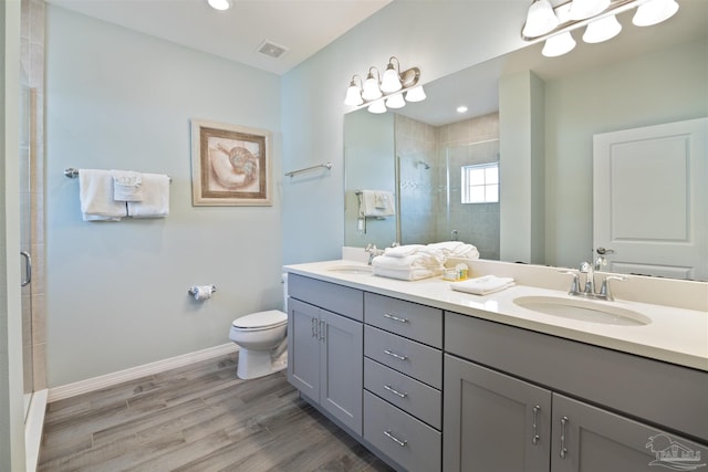 bathroom with vanity, hardwood / wood-style flooring, toilet, and a shower with shower door