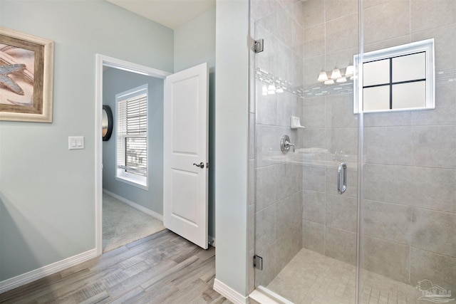 bathroom featuring hardwood / wood-style floors, a shower with shower door, and a chandelier