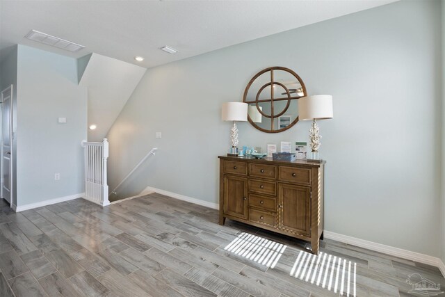 interior space featuring light hardwood / wood-style floors and lofted ceiling