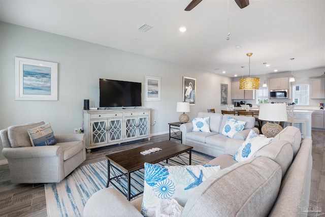 living room featuring light hardwood / wood-style flooring and ceiling fan