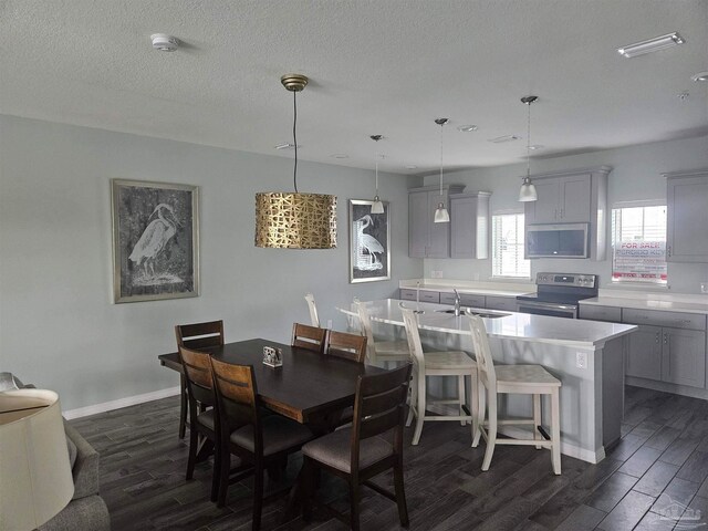 dining space with a textured ceiling, dark hardwood / wood-style flooring, and sink