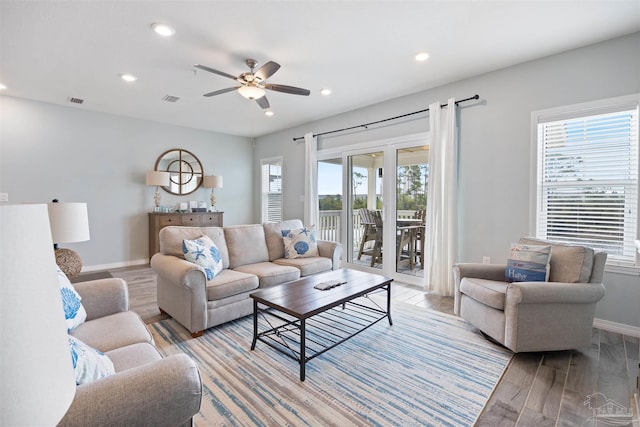 living room featuring light wood-type flooring, plenty of natural light, and ceiling fan