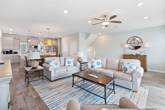 living room with ceiling fan and light wood-type flooring