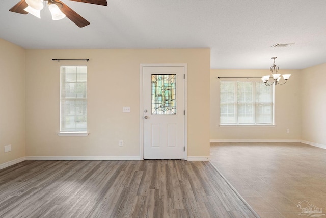 foyer entrance featuring hardwood / wood-style floors and ceiling fan with notable chandelier